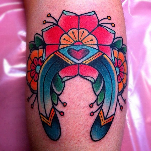 Red flowers and horse shoe tattoo