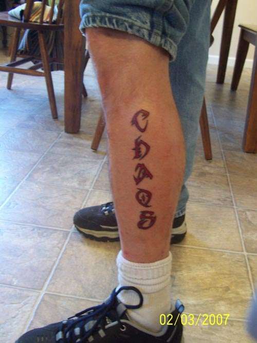 Red letters and quote tattoo on leg