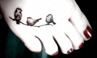 Red nails and black bird tattoo