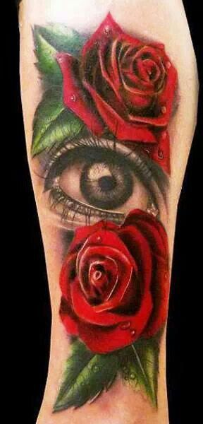 Red roses and amazing eye tattoo on arm