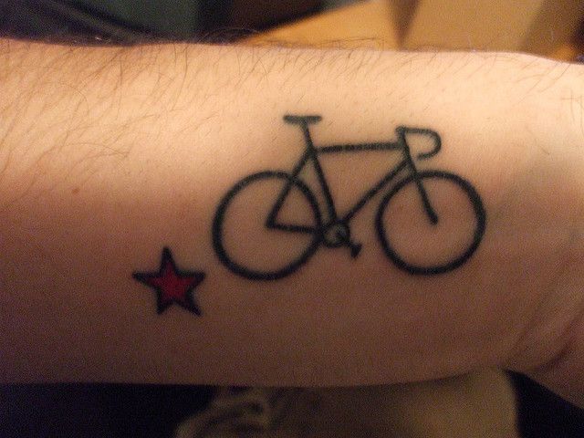 Red star and bicycle tattoo on arm