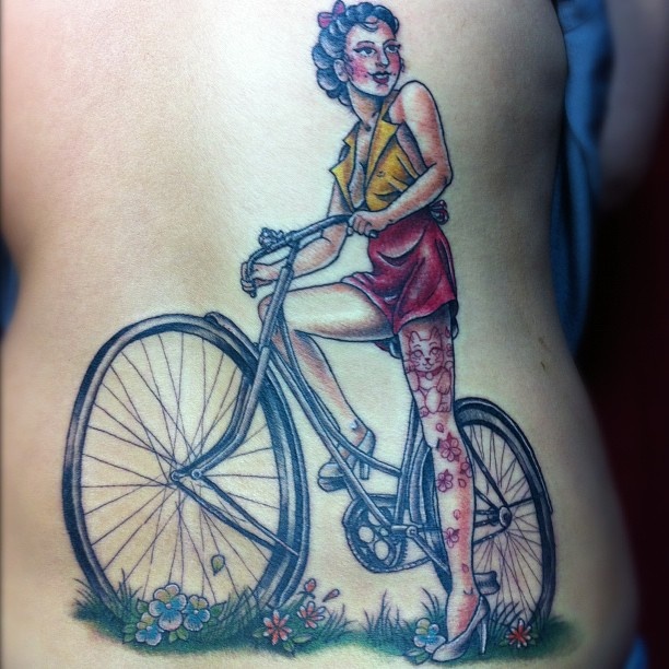 Red women’s bicycle tattoo on back