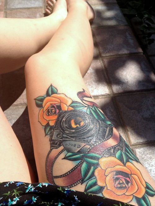 Rose flowers and camera tattoo on leg