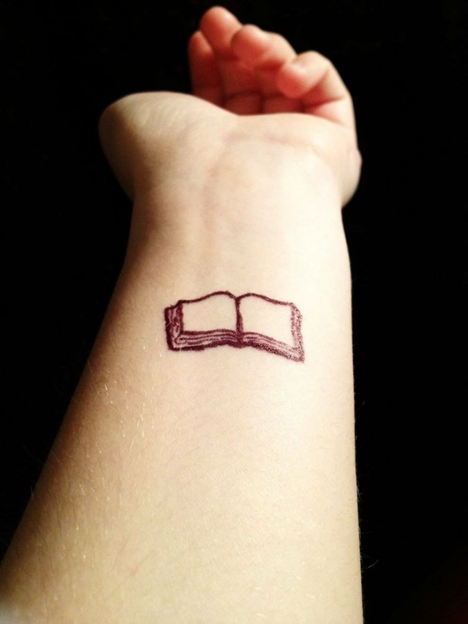 Small and pretty book tattoo on arm