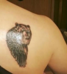 Small brown bear tattoo on shoulder