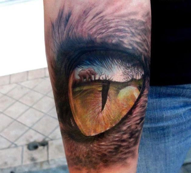 Small elephant and eye tattoo on arm