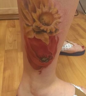 Watercolor yellow and red poppy tattoo on leg