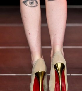 Women high-heels and eye tattoo on leg