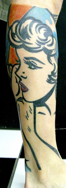 Women’s face line tattoo on leg