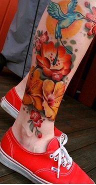 Yellow and red bird tattoo on leg