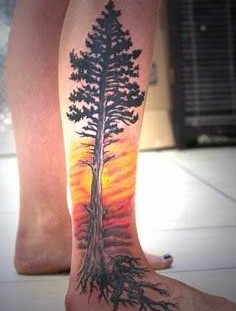 Yellow fire and tree tattoo on leg