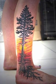 Yellow fire and tree tattoo on leg