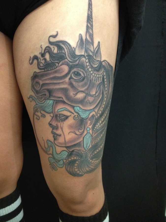 unicorn tattoo with woman face on the thigh