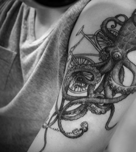 Bike and black octopus tattoo on arm