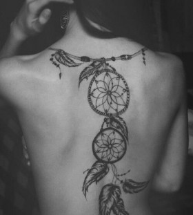 Black leafs and compass tattoo on back