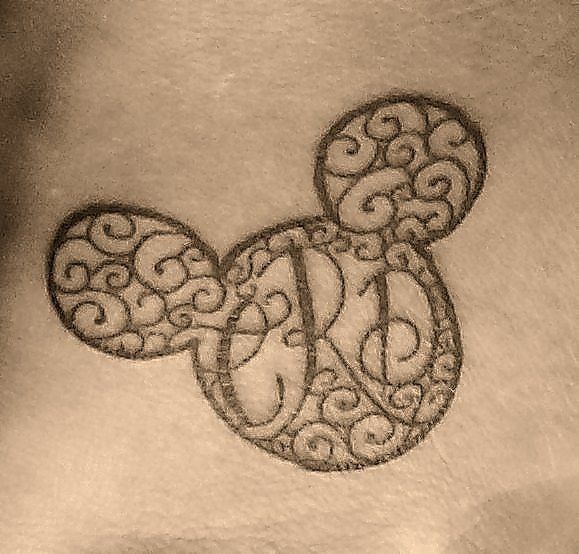 Black ornaments with Mickey Mouse tattoo on arm