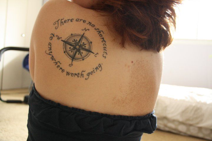 Black quoites compass tattoo on back