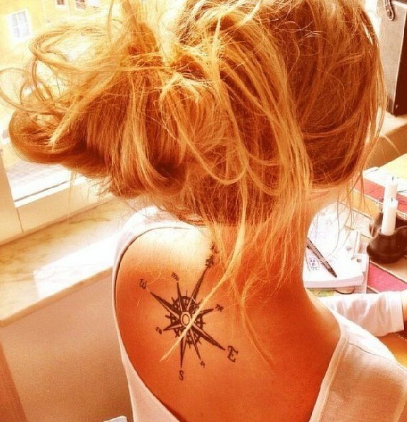 Blonde girl compass tattoo on back