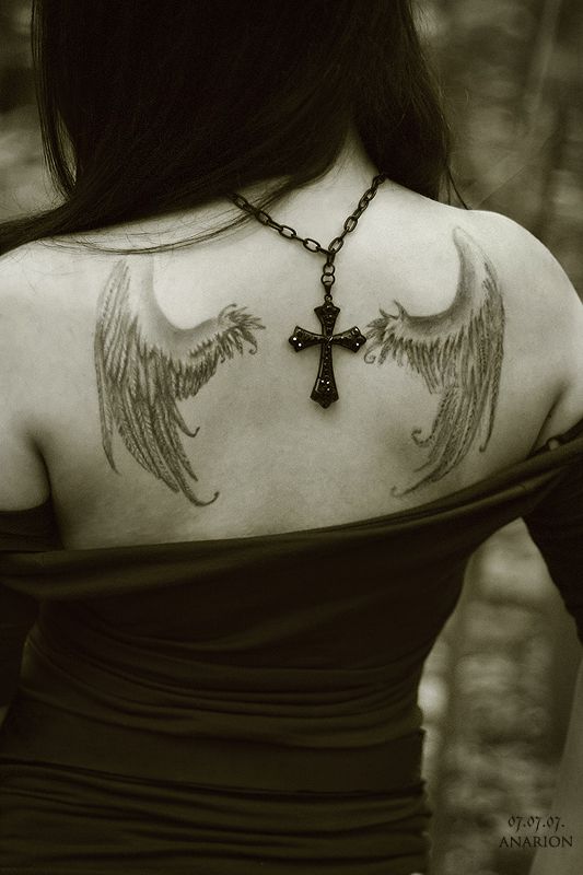 Cross and black angel tattoo on shoulder