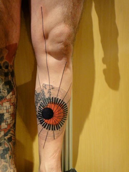 Orange and black geometric tattoo on leg