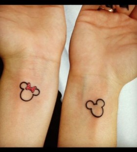 Red bow Mickey Mouse tattoo on arm