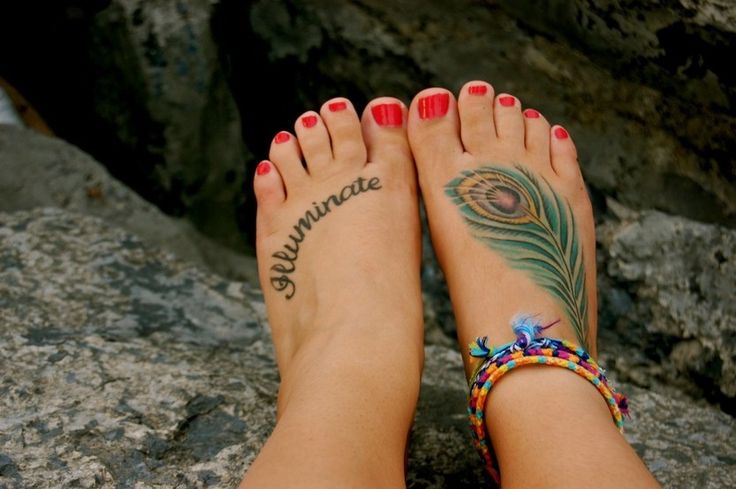 Red nails and quote peacock tattoo on leg