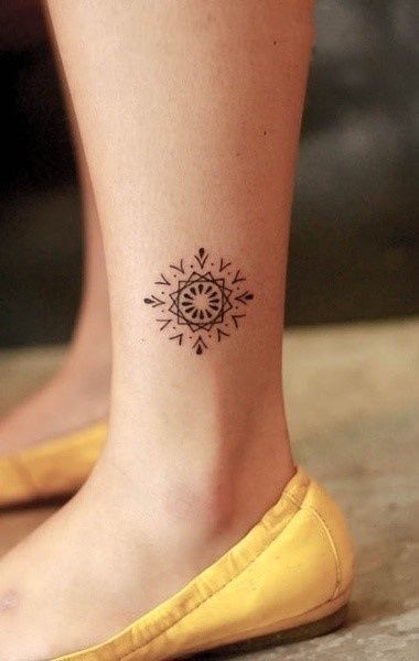 Yellow shoes and geometric tattoo on leg