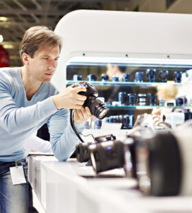 Man photographer tests digital SLR camera in shop