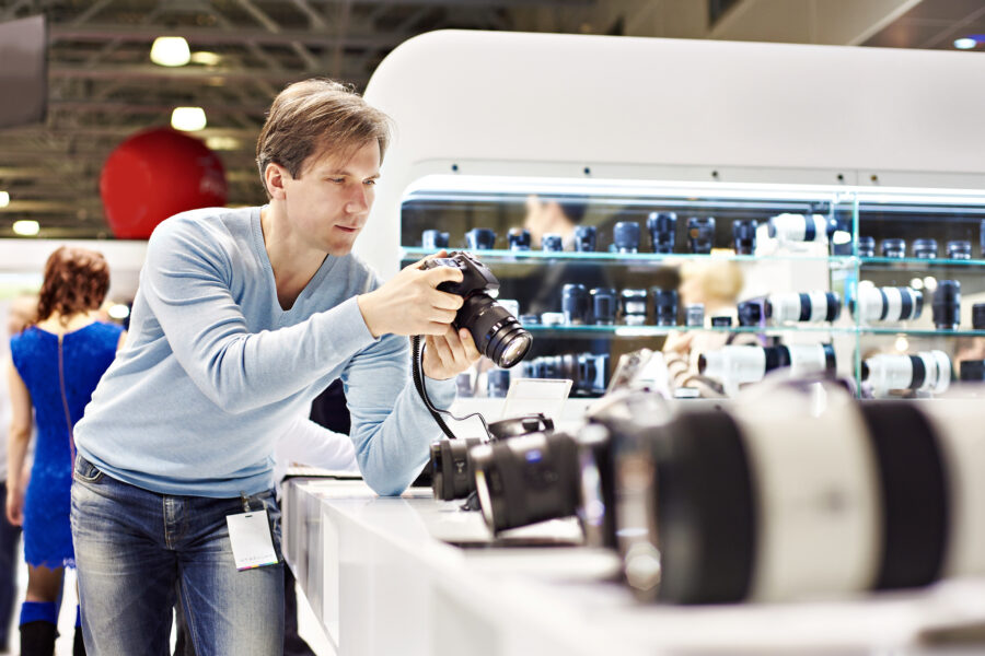 Man photographer tests digital SLR camera in shop