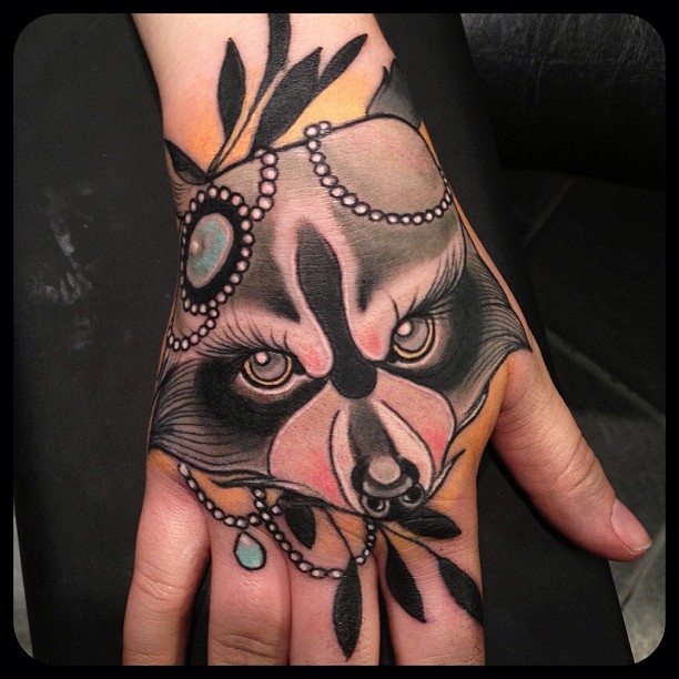 Amazing raccoon face hand tattoo