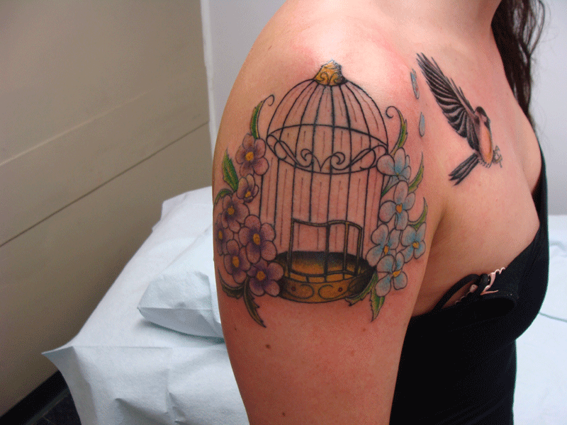 Birdcage and colourful flowers tattoo