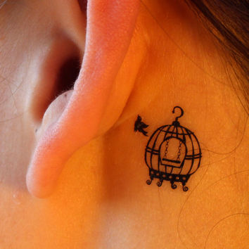 Birdcage behind ear tattoo