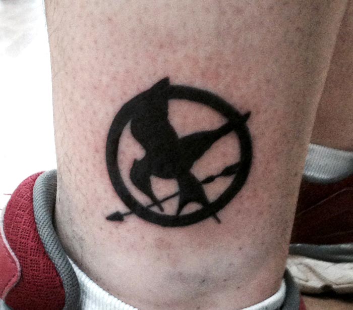 Black ink mockingjay logo tattoo