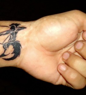 Black ink sagittarius wrist tattoo