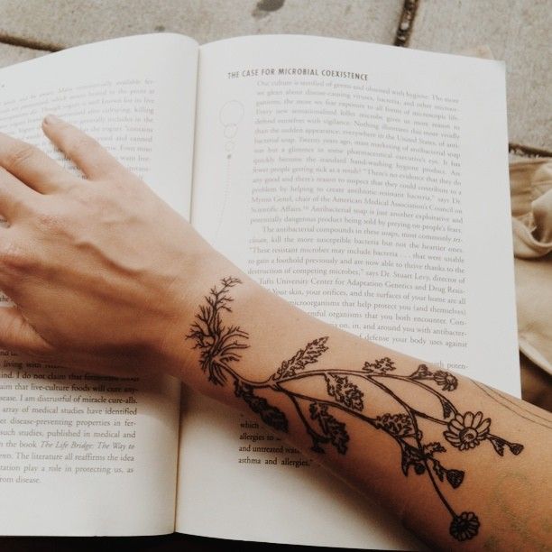 Book and plants arm tattoo