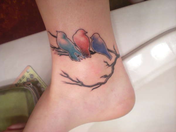 Colourful birds on a branch tattoo