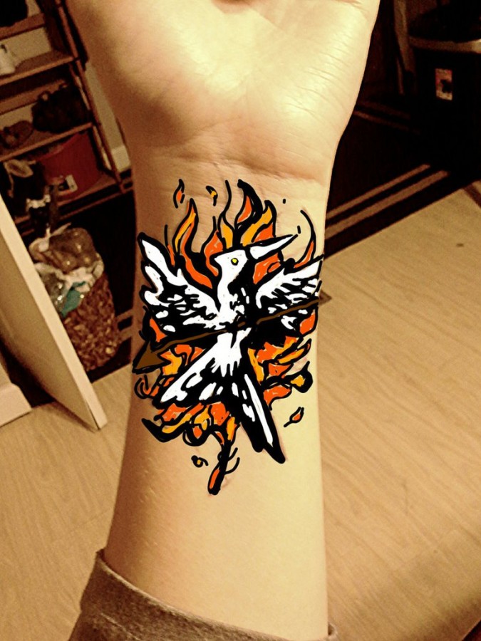 Flaming mockingjay wrist tattoo