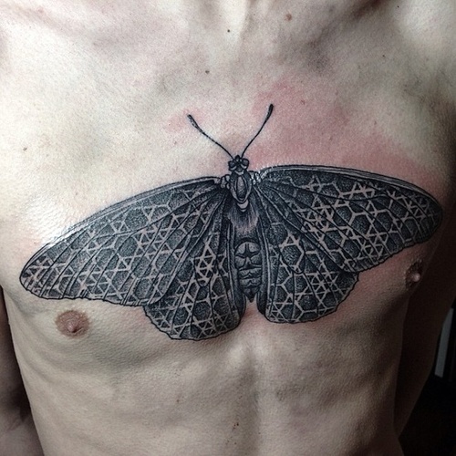 Large moth chest tattoo