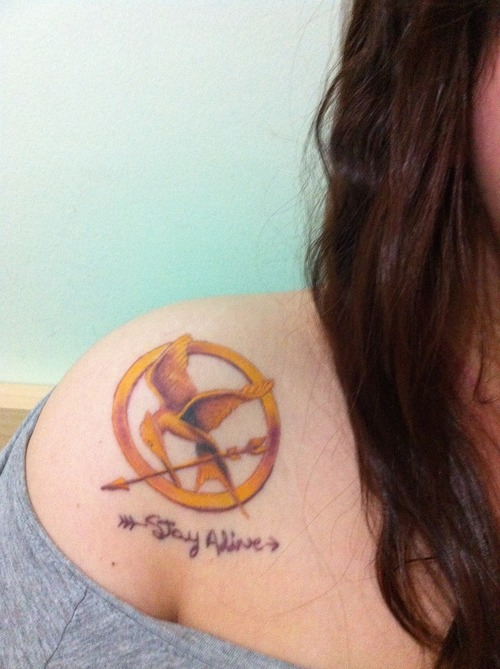 Lovely mockingjay logo shoulder tattoo