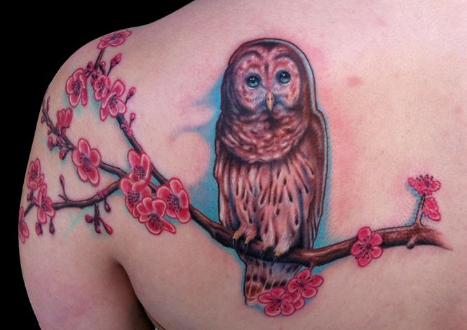 Owl on a tree branch tattoo