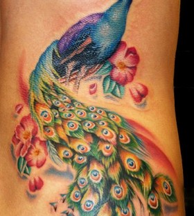 Peacock on woman's body watercolor tattoo