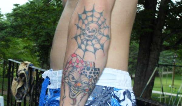 Spider web and clown tattoo