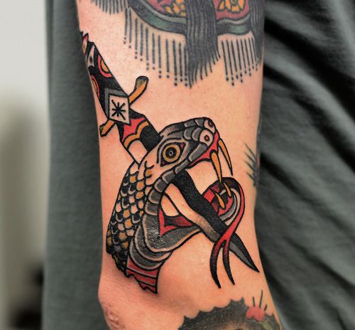 Stabbed snake with a dagger tattoo by Philip Yarnell