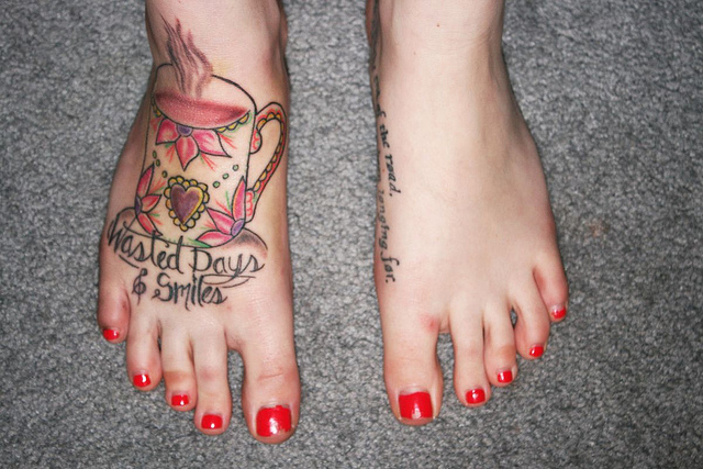 Teacup and writing foot tattoo