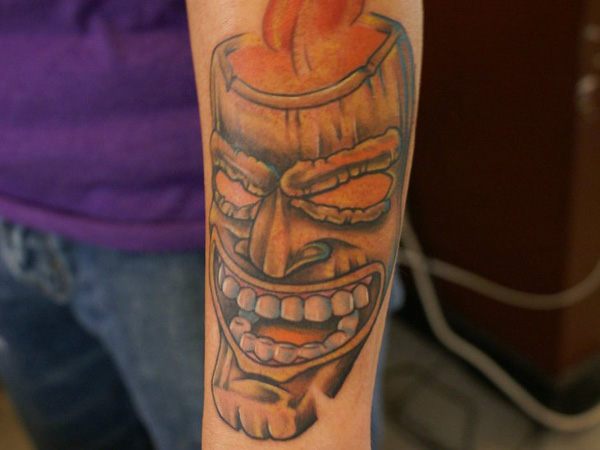 Tiki mask arm tattoo