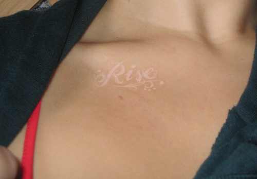 Rise Word White Ink Tattoo on Forearm